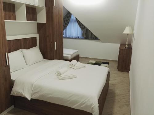 a bedroom with a bed with two towels on it at Lovac apartmani in Zlatibor