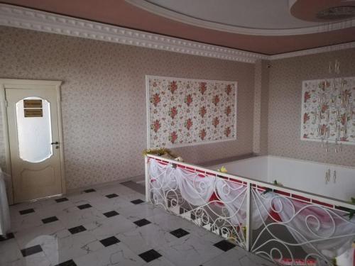 una habitación con una escalera y una puerta con flores en la pared en Керуен сарайы, гостиница, en Aralʼsk