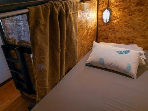 een bed in een kamer met een kussen erop bij Spinning Cat Hostel in Tagbilaran-stad