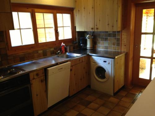 a kitchen with a sink and a washing machine at L'Eau-Vive in Leukerbad