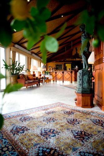 a living room with a rug and a statue in a room at Montra Odder Parkhotel in Odder