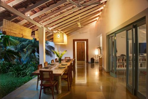 a dining room with a long table and chairs at Assagao Bay by the Rose Nomad in Assagao