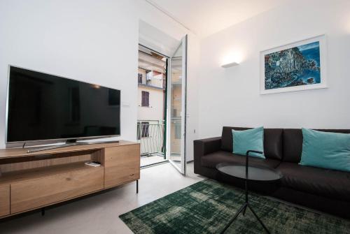 a living room with a couch and a flat screen tv at Luxury Apartment Manarola by Arbaspàa in Manarola