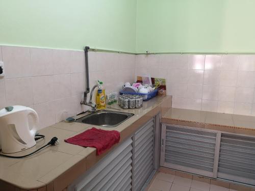 a kitchen with a sink and a counter top at Kelly Cozy cottage in Kampar