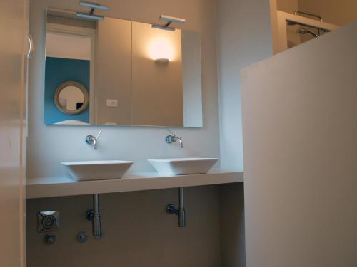 a bathroom with two sinks and a mirror at Cosmopolitan Central Rooms in Bologna