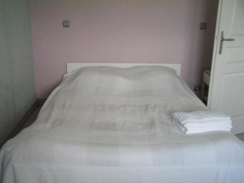 ein weißes Bett mit einem Haufen Handtücher drauf in der Unterkunft la maison d'Amélie in Saint-Fort-sur-Gironde