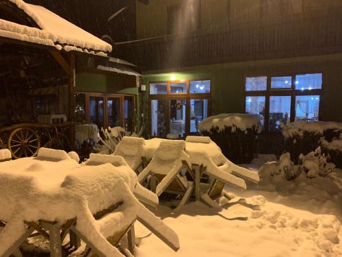 a room covered in snow with tables and chairs at Pensiunea Ghiocelul in Avrig
