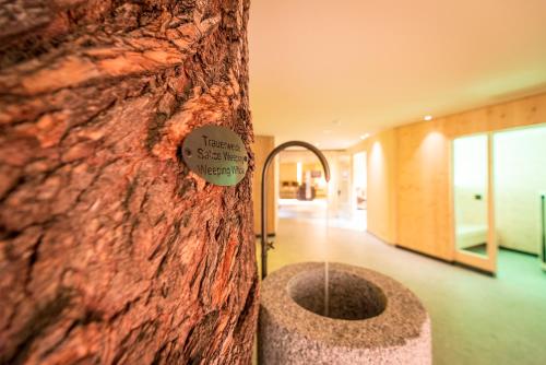 a tree with a sign on the side of it at Hotel Mühlenerhof in Campo Tures