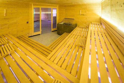 an empty room with wooden benches in a building at Hotel Mühlenerhof in Campo Tures