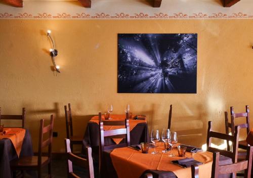a dining room with tables and chairs and a painting on the wall at Indren Hus in Alagna Valsesia