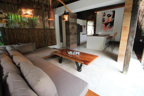 a living room with a couch and a wooden table at La Cabane in Jimbaran
