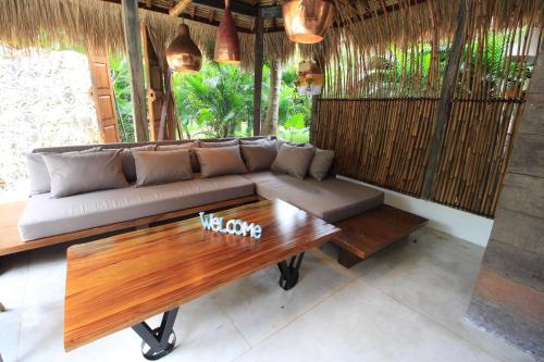 a living room with a couch and a wooden table at La Cabane in Jimbaran