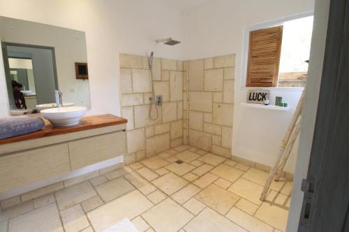a bathroom with a shower with a sink and a mirror at La Cabane in Jimbaran