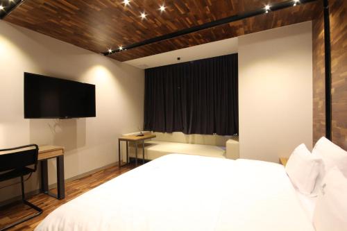 a bedroom with a bed and a flat screen tv at Hotel Eco stay in Jeonju