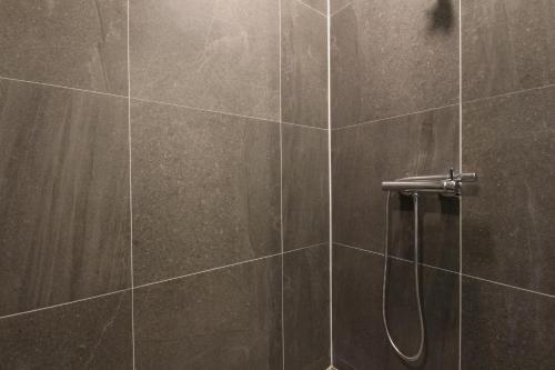 a bathroom with a shower with brown tiles at Hotel Eco stay in Jeonju