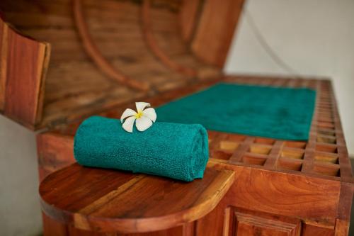 a green towel with a flower on it on a table at Hotel Sigiriya in Sigiriya