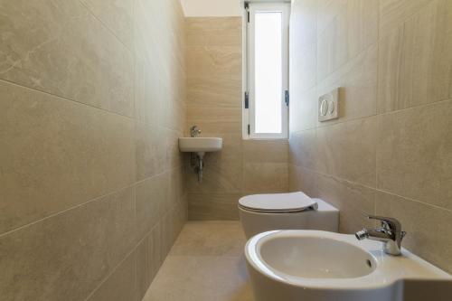 a bathroom with a sink and a toilet and a window at Hotel Capo Reamol in Limone sul Garda