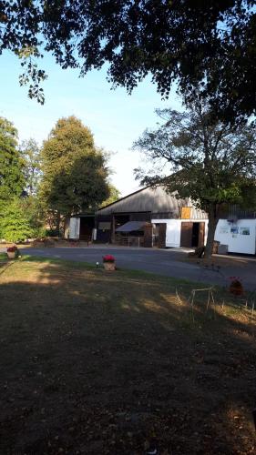 ein Gebäude mit einem Baum und einem Hof mit einem Haus in der Unterkunft Ferienhof Papiermühle in Hofgeismar