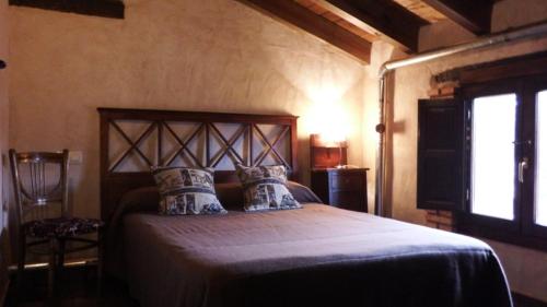 1 dormitorio con 1 cama grande en una habitación con ventana en Casa Rural La Ossa en Ossa de Montiel