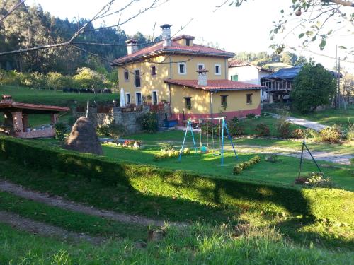a house with a yard with a playground at Casa Rural Casa Capión in Villaviciosa
