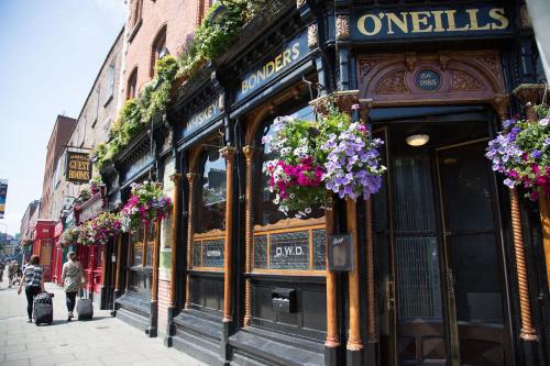 a building with flowers on the front of a street at O'Neills Victorian Pub & Townhouse in Dublin
