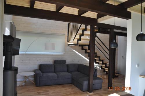 a living room with a couch and a staircase at Jaśminowy Sad in Mikołajki