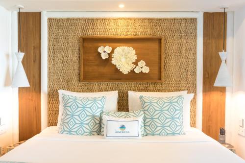 a bedroom with a bed with blue and white pillows at Seasense Boutique Hotel & Spa in Belle Mare