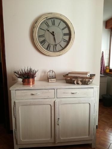 a clock on the wall above a white cabinet at Giuly Home in Caspoggio