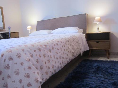 a bedroom with a large bed with a floral bedspread at Blue Yard Apartments in Kalamata