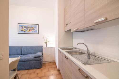 a kitchen with a sink and a blue couch at Residenza Miola in Saronno