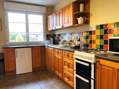 une cuisine avec des armoires en bois et un four à plaques de cuisson dans l'établissement Coury House, Chavasse Farm, Somme, à Hardecourt-aux-Bois