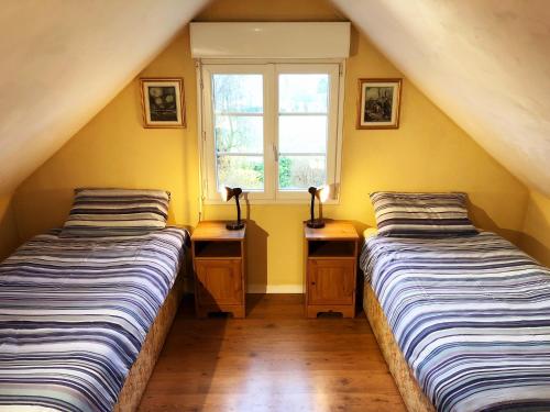 two beds in a room with yellow walls and a window at Coury House, Chavasse Farm, Somme in Hardecourt-aux-Bois