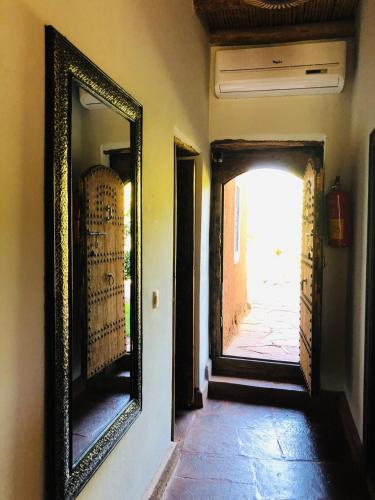 a mirror on a wall next to a hallway at Les Jardins de Taja in Ourika
