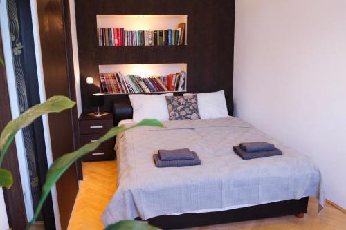 a bedroom with a bed with two towels on it at Palace Apartman - Minaret, Eger in Eger