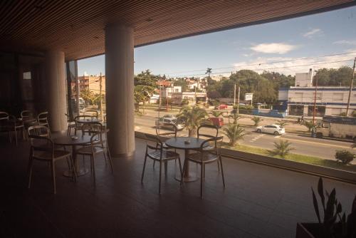 balcón con mesas y sillas y vistas a la calle en Hotel Estilo MB - Villa Carlos Paz, en Villa Carlos Paz
