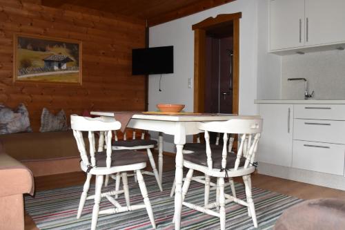 eine Küche mit einem Tisch und 2 Hockern in der Unterkunft Haus Schwaighofer in Neukirchen am Großvenediger