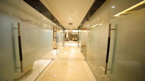 un pasillo de un edificio con paredes de cristal en Dhamma Grand Hotel Resort, en Bodh Gaya