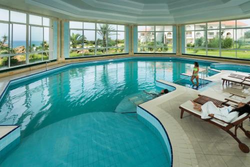 a large swimming pool in a building with windows at Thabraca Thalasso & Diving in Tabarka