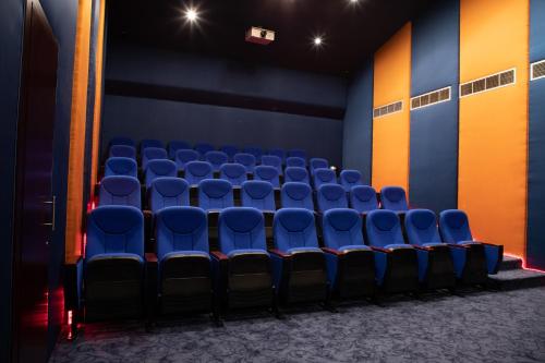 an empty auditorium with blue chairs in a room at Orange Suites Hotel in Manama