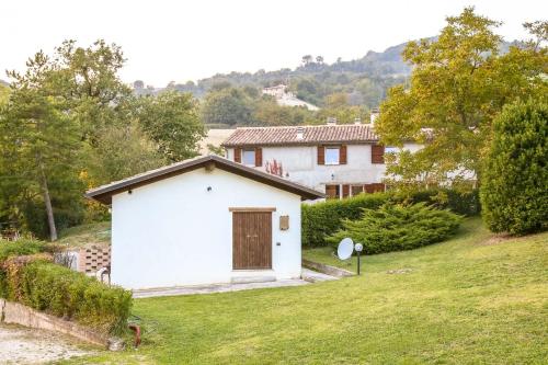 a small white building in a yard with a house at Casale di Nicolò in Urbino