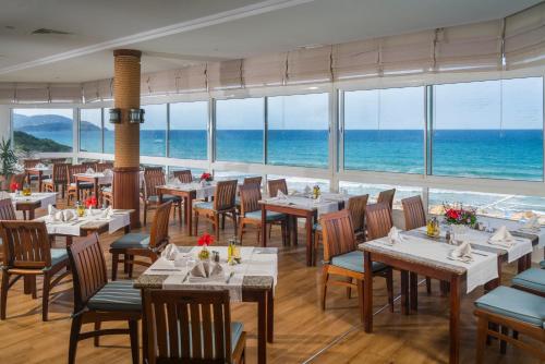 a restaurant with tables and chairs and the ocean at Thabraca Thalasso & Diving in Tabarka