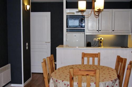 a kitchen with a table and some chairs and a kitchen with a table at Epicea Avoriaz, three bedroom apartment, 62 m2, 4th floor, 8 ppl in Avoriaz