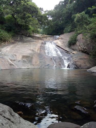 a waterfall in the middle of a river at The Inn At Matale in Matale