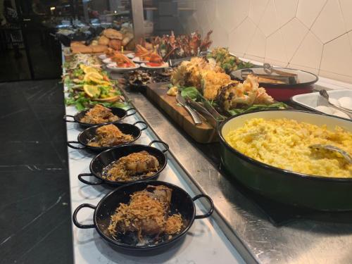 un buffet con muchos platos diferentes de comida en una barra en Golden Crown Haifa, en Haifa