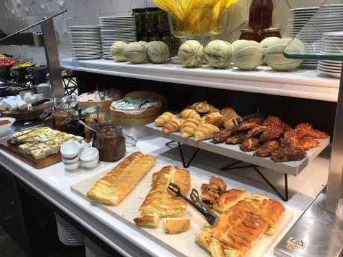 Una línea de buffet con diferentes tipos de pan y pasteles. en Golden Crown Haifa, en Haifa