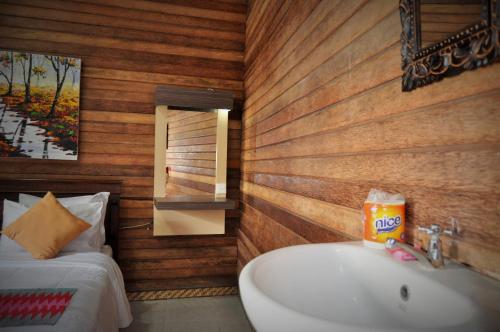 a bathroom with a white sink and a bed at The Mel Homestay in Nusa Penida