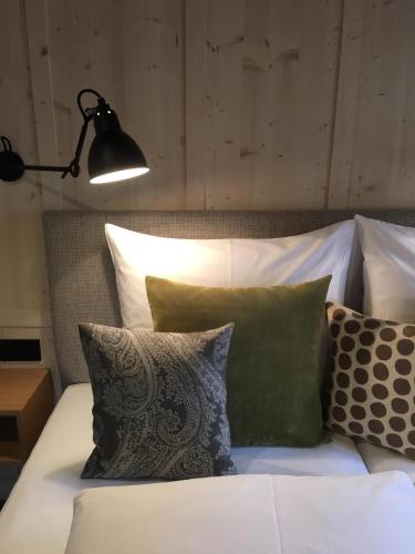 a bedroom with a bed with pillows and a lamp at Pension Alpenfluh in Lech am Arlberg