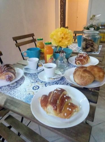 een tafel met borden met zoete deegwaren en croissants bij B&B Belvedere in Napels