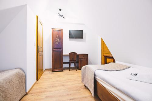 a hotel room with two beds and a desk at Willa 35 in Leśnica
