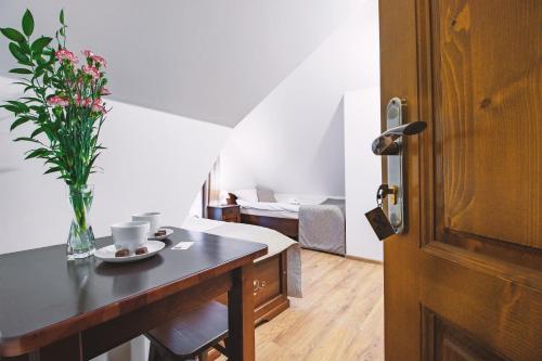 a room with a table with a vase of flowers on it at Willa 35 in Leśnica